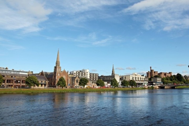 City skyline with river, church spires, and a clear blue sky.
